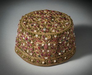 Jewel encrusted Muslim Royal Cap Mughal style, made by Ezra & Sion Co, Bombay, early 20th century Green velvet cap, embroidered with twisted gold thread, gold sequins and encrusted with pearls, rubies, spinels and emeralds. Lined in satin and edged inside in leather around the base of the cap. Stamped on leather 'Primus' 'Ezra & Sion Co., 95-97 Ghendy Bazaar, Bombay' 'Perfect Ventilation - Latest Combination' Height: 10 cm; Diameter: 15.5 cm Francesca Galloway Ltd